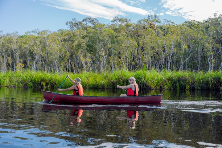 a group of people in a small boat in a body of water
