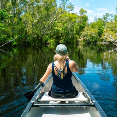 a person riding on the back of a boat in a body of water