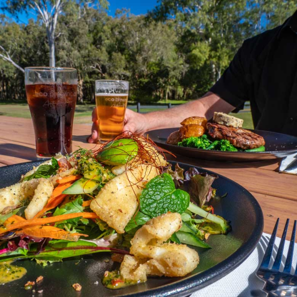 a person sitting at a table with a plate of food