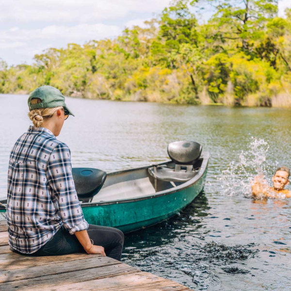 a man in a green boat on a body of water